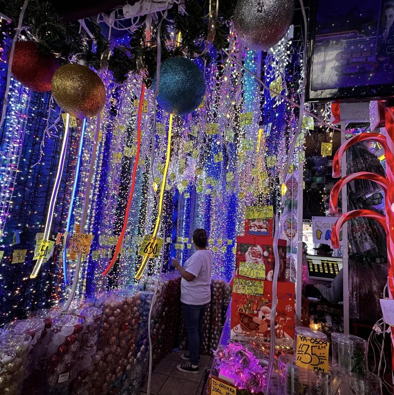 Tienda llena de series y cortinas de luces navideñas encendidas